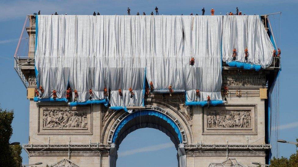 Workers install a shimmering wrapper to envelop Paris landmark, the Arc de Triomphe