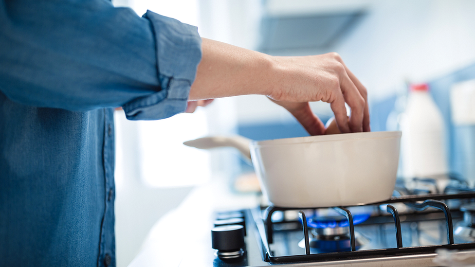 Woman cooking on gas stove