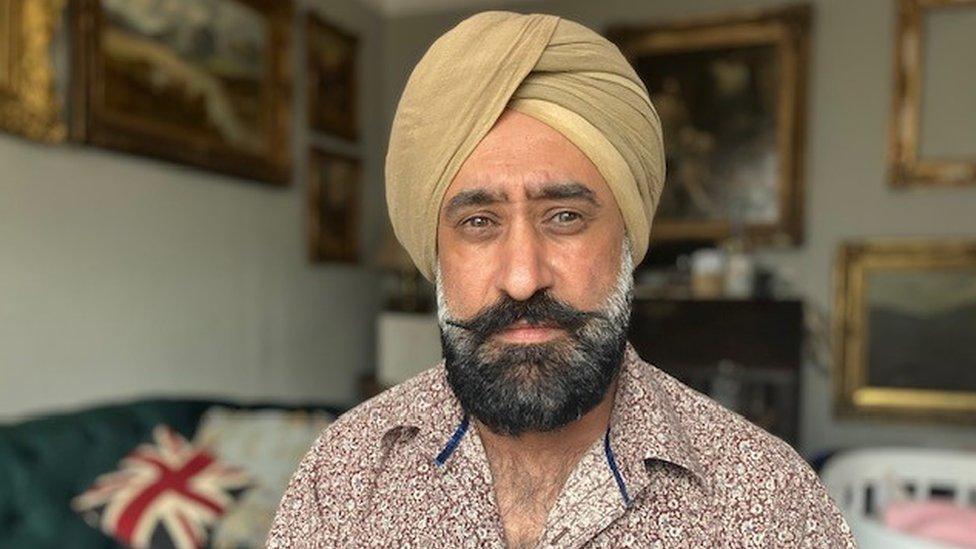 Pharmacy - Max Punni - a man in a tan-coloured turban and floral shirt looking to the camera