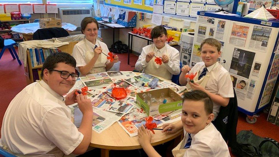 School children making poppies out of plastic bottles