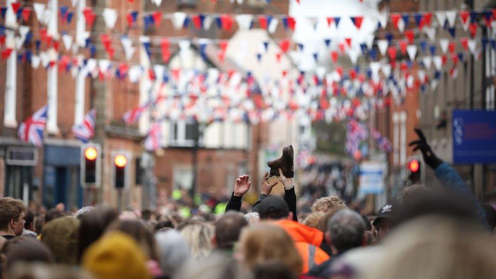 The Royal Shrovetide football game in Derbyshire - a shoe is passed over the heads of the players