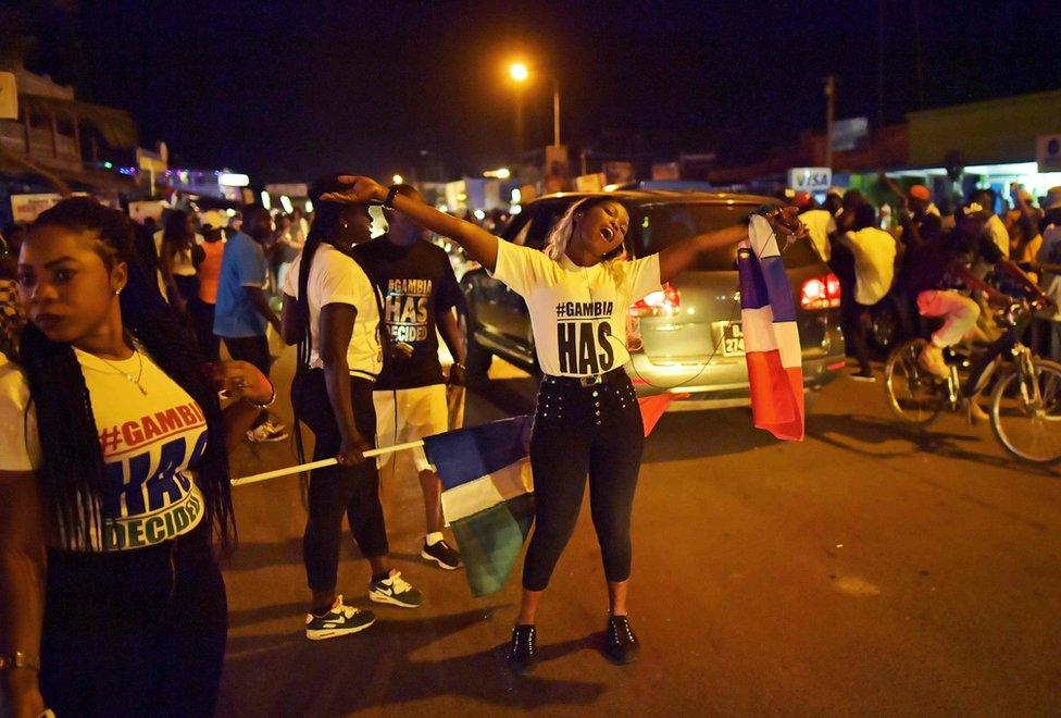 People celebrate in the streets after hearing of the confirmed departure of former Gambian leader Yahya Jammeh in Banjul on 21 January