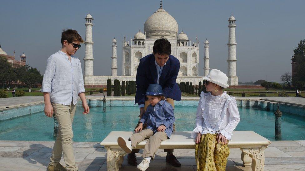 Justin Trudeau getting his children set up for a photo in front of the Taj Mahal