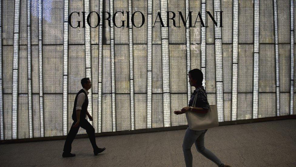 People walking past a store of top Italian designer Giorgio Armani in Hong Kong