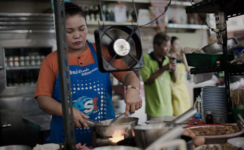 A woman works in restaurant kitchen in Thailand