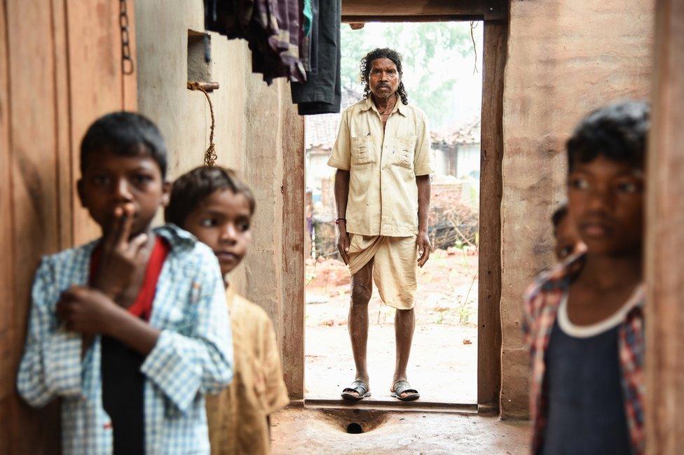 An elderly man in traditional Indian cloths pictured here, with some of his grandchildren.