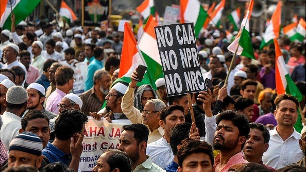 Demonstrators hold Indian national flags and placards as they protest against India's new citizenship law during a demonstration in Kolkata on February 28, 2020. (Photo by Dibyangshu SARKAR / AFP)