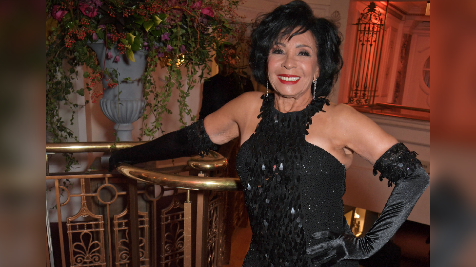 Shirley Bassey looking at the camera wearing a black dress