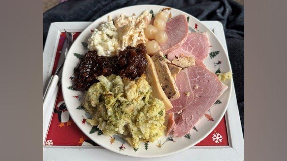 Kate's dinner on the plate, which includes pickled onions, ham slices and mashed vegetables.