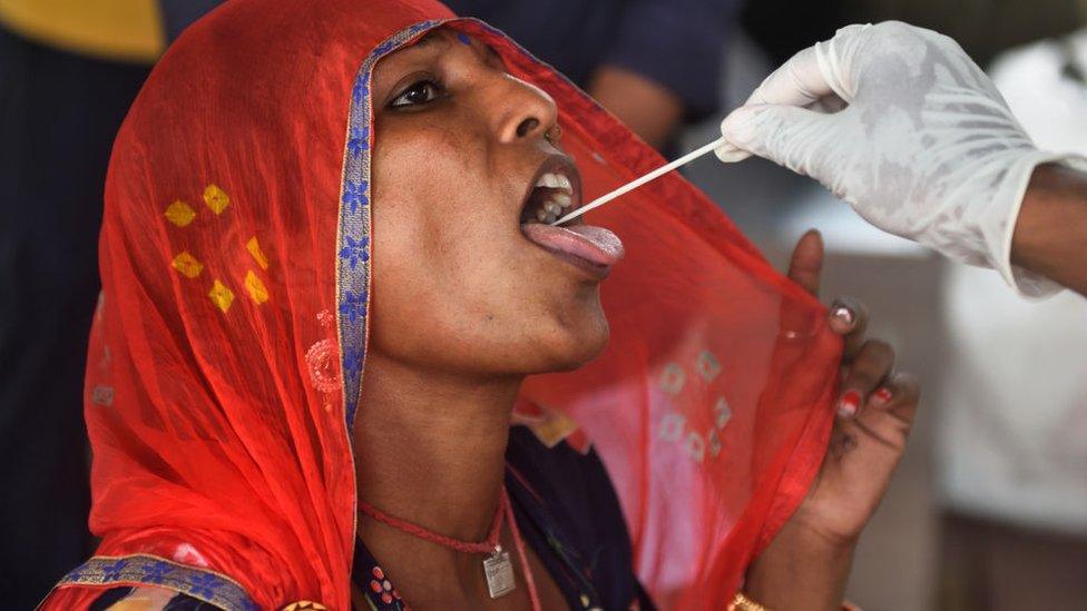 A BMC health worker collects a swab sample of a passenger for Covid-19 test, at Dadar Station, on July 16, 2021 in Mumbai, India