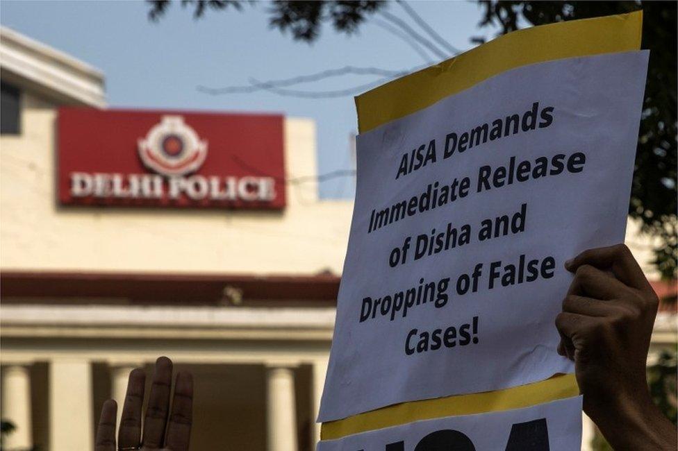 A demonstrator holds a placard during a protest against the arrest of 22-year-old climate activist Disha Ravi, outside the police headquarters in New Delhi, India, February 16, 2021.