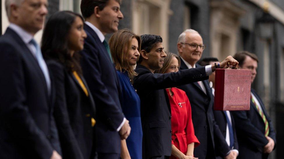 Rishi Sunak a thim y Trysolrys o flaen 11 Downing Street gyda'r focs goch