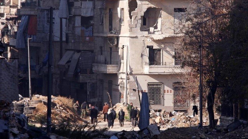 People, who evacuated the eastern districts of Aleppo, carry their belongings as they walk in a government held area of Aleppo, Syria on 9 December 2016.