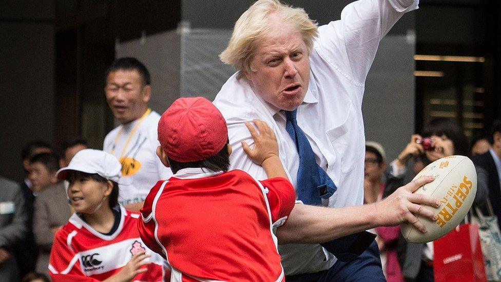 Boris Johnson joining a Street Rugby tournament in a Tokyo street with school children and adults