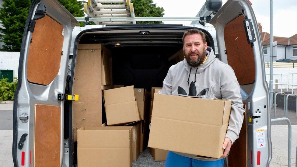 A man carrying carboard boxes