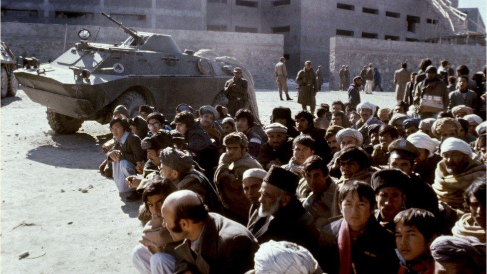 Afghans wait outside the Kabul central Pulicharkhi prison 14 January 1980 days after the Moscow-installed regime of Babrak Karmal took over