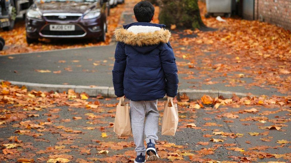 Child carrying lunch bags