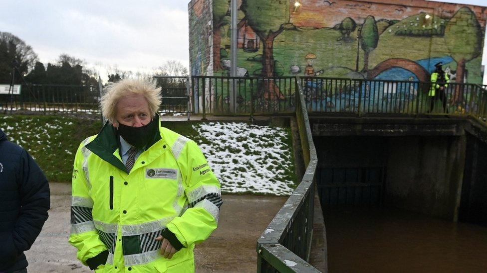 Prime Minister Boris Johnson talks with Environment Agency workers during a visit to a storm basin near the River Mersey in Didsbury