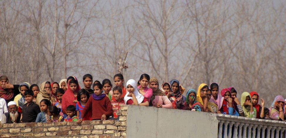 Villagers watch Akhilesh Yadav's rally from the roof of a nearby home