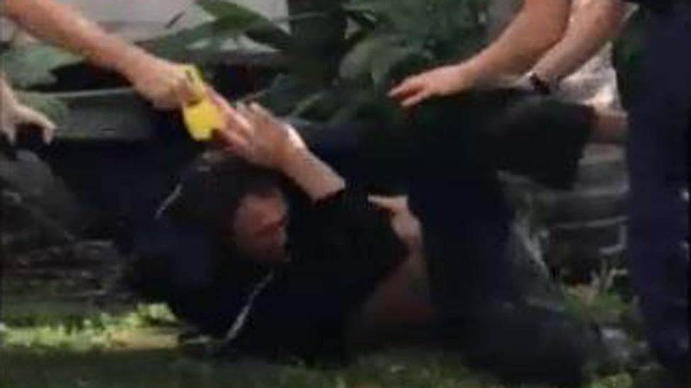 Kris Bradshaw writhes on the ground while being tasered