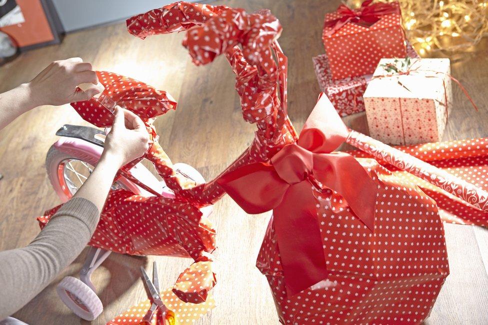 A bike being covered in wrapping paper