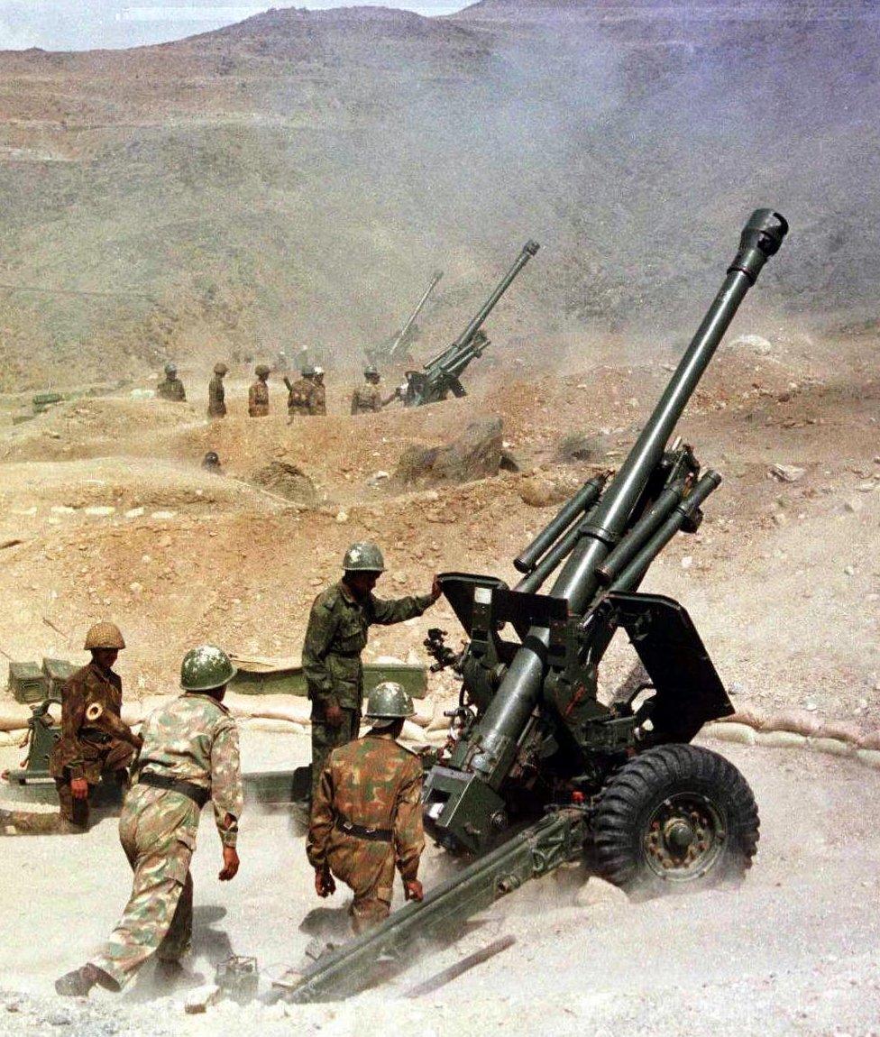 Soldiers from the Indian army fire their 105mm guns, 31 May 1999, from their outpost near Kargil towards the India-Pakistan border in Kashmir.