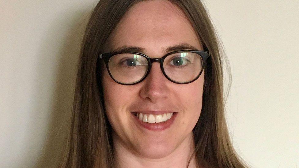 A head shot of Dr Julia Farley. She has long light brown hair, is wearing dark-framed glasses and is smiling at the camera.