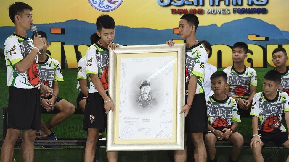 Rescued Thai football coach Ekkapol Chantawong (left) together with 12 children pays tribute to Saman Gunan during a press conference in Chiang Rai, 18 July 2018