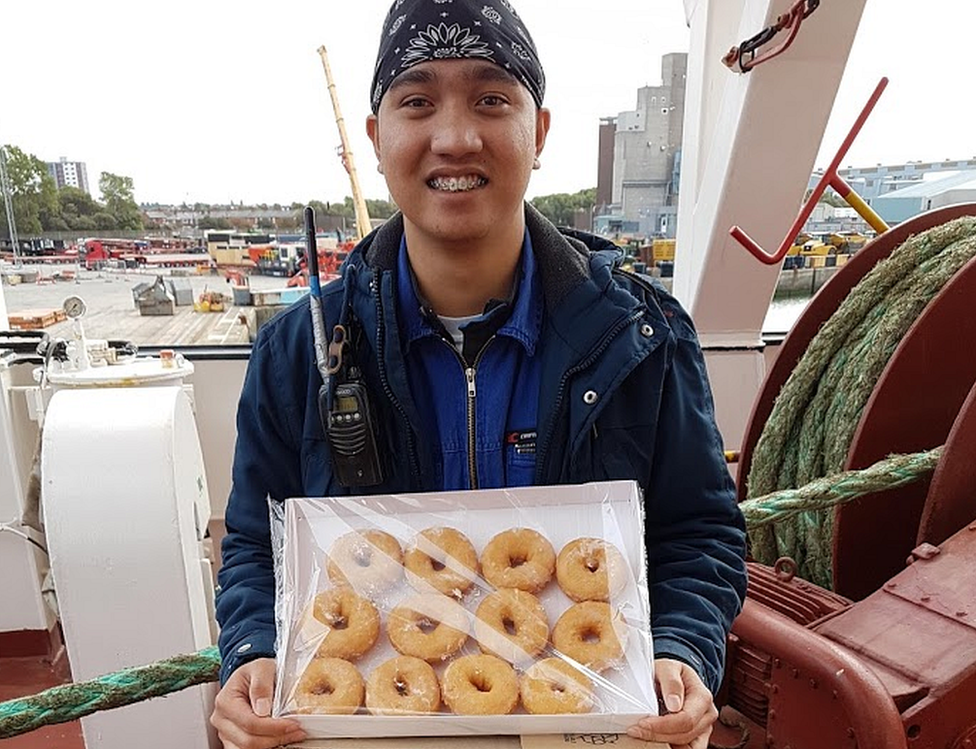 Man holds box of doughnuts