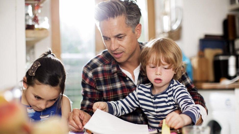 Dad supervising children learning