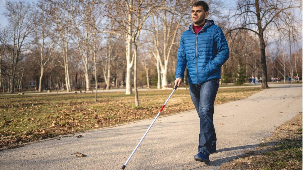 blind-man-using-stick-walking-outside.