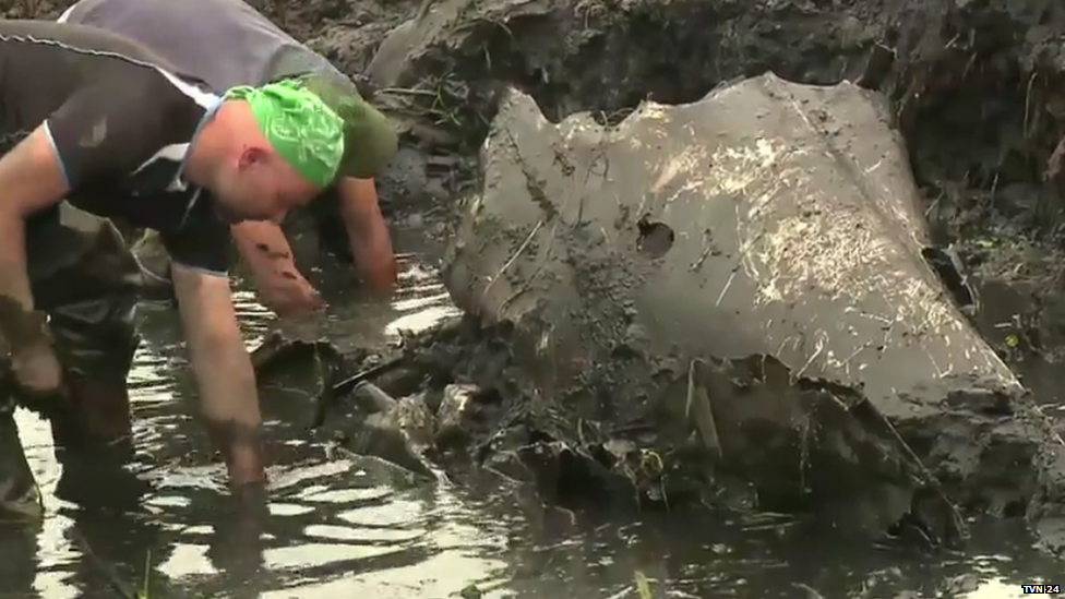 Two men digging out the plane wreck