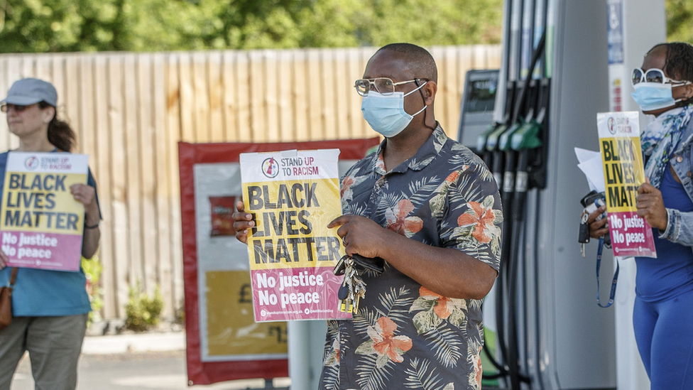 People hold "Black Lives Matter" posters