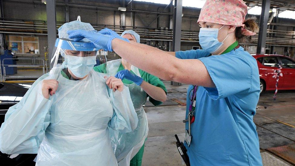 Medical staff put on their personal protective equipment.