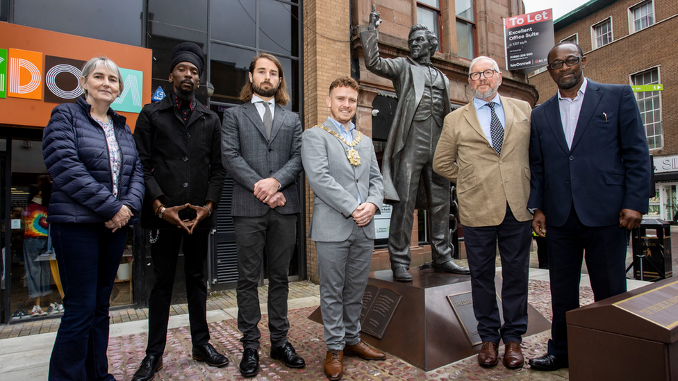 Anna Slevin from the Department for Communities, Takuri Makoni from the African and Caribbean Support Organisation NI (ACSONI), sculptor Hector Guest, Belfast Lord Mayor Councillor Ryan Murphy, sculptor Alan Beattie Herriot and Reverend Dr Livingstone Thompson from ACSONI at the unveiling of a statue of anti-slavery campaigner and author Frederick Douglass in Belfast city centre.