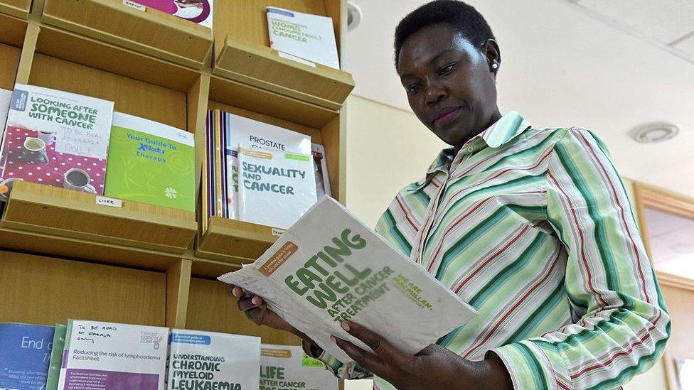 Kenyan school teacher and breast cancer survivor Rose Kariuki reads pamphlets at the Faraja cancer care centre in Nairobi on December 19, 2016