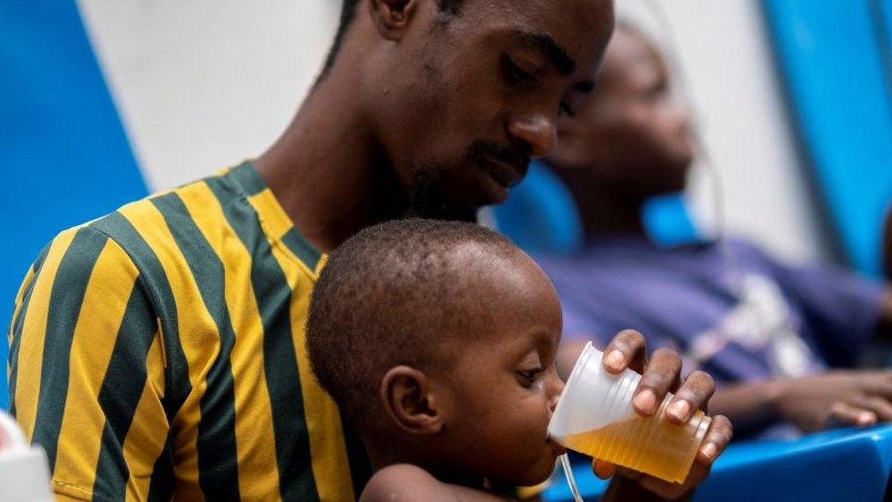 Pierre Michel Louis gives oral serum to his son Giovens Pierre Louis, 2, as he receives treatment for cholera at the Gheskio Center Hospital supported by UNICEF in Port-au-Prince, Haiti, October 14, 2022.