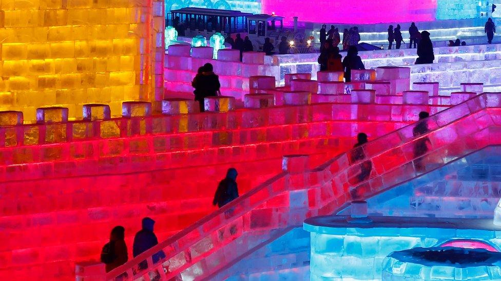 People visit the ice sculptures illuminated by coloured lights at Harbin ice and snow world for the 33rd Harbin International Ice and Snow Festival in Harbin city, China's northern Heilongjiang province, 05 January 2017.