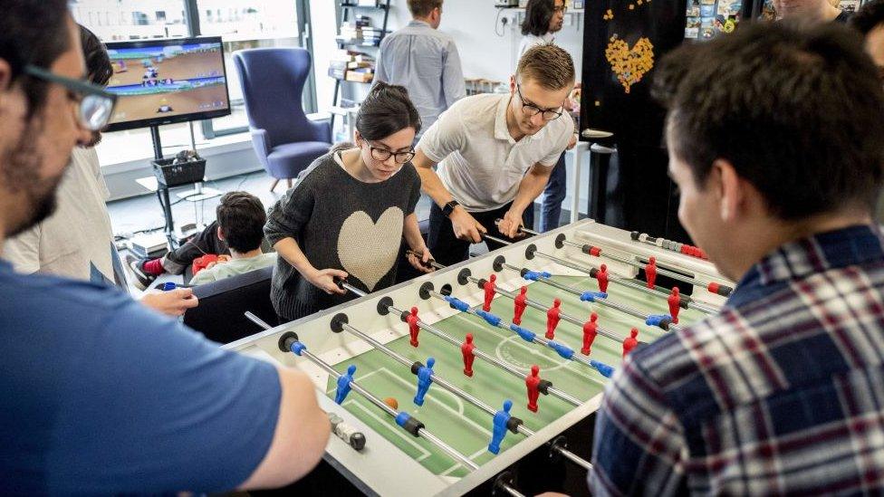 Employees of Smarkets play table football during their lunch break at their office in central London on March 12, 2018