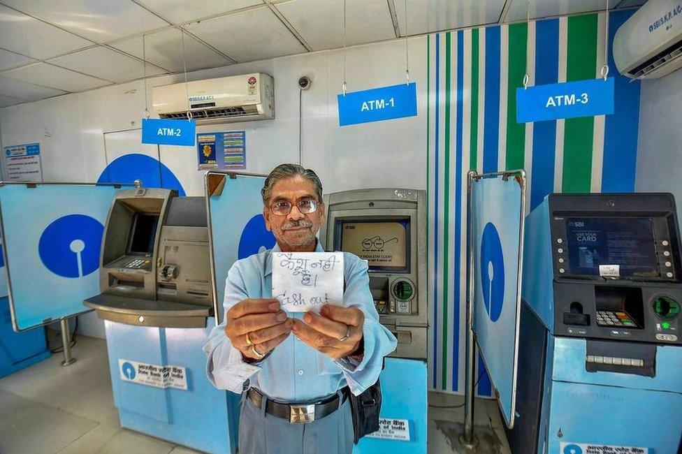 A man shows a “no cash” slip near SBI ATMs in Patna on April 17, 2018. Most of the ATMs have run out of cash in the city