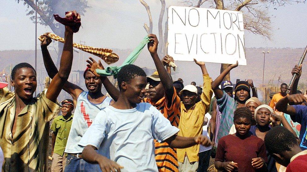 Residents wave "no more eviction" placard in Porta Farm slum, west of Harare, July 2005