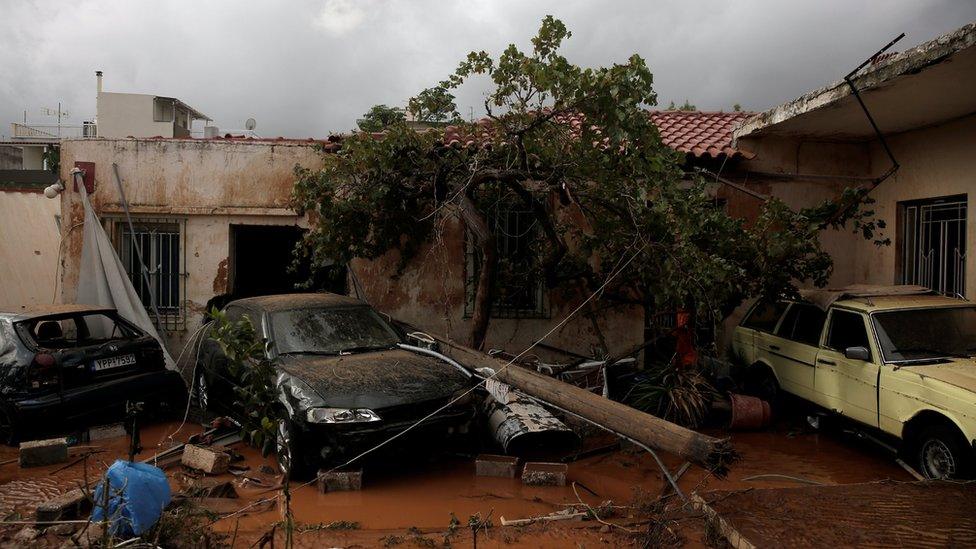 Destroyed cars are seen inside a yard following heavy rainfall in the town of Mandra