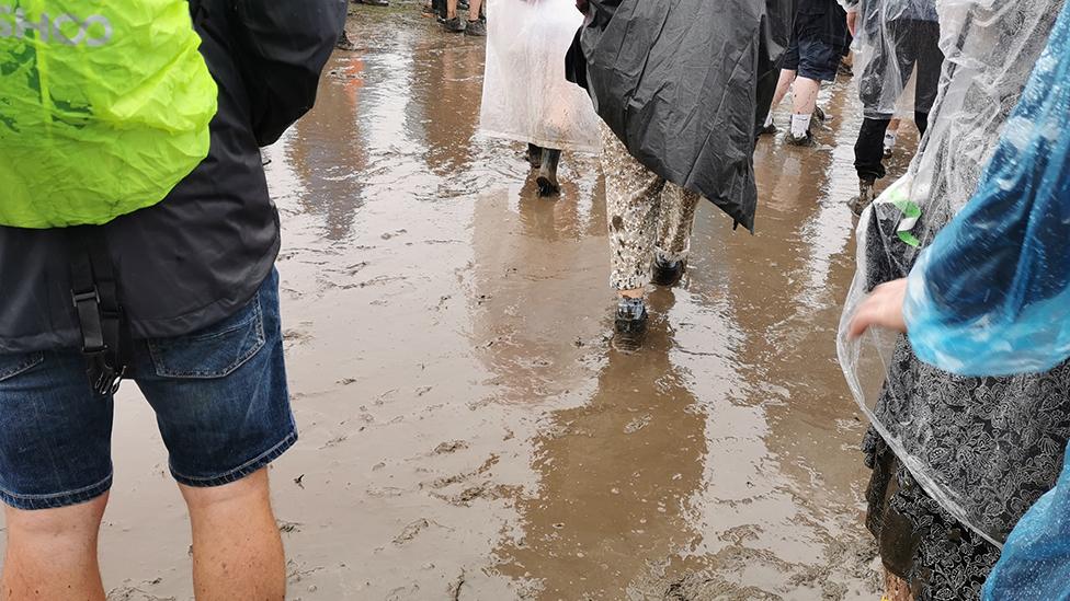 Crowd walking through mud