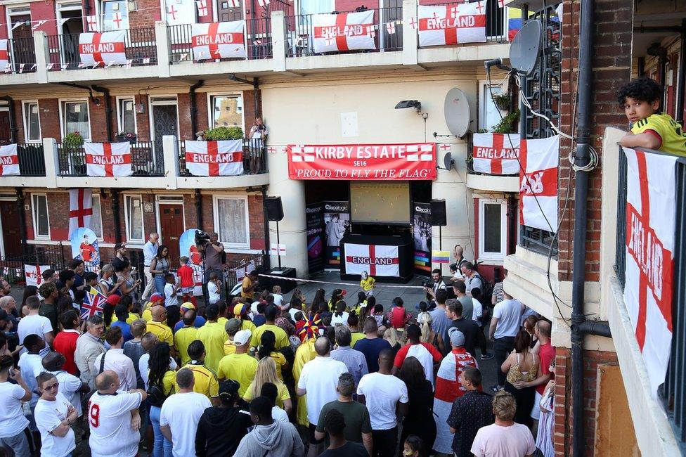 Residents of the Kirby Estate in London watch England play in the World Cup on television