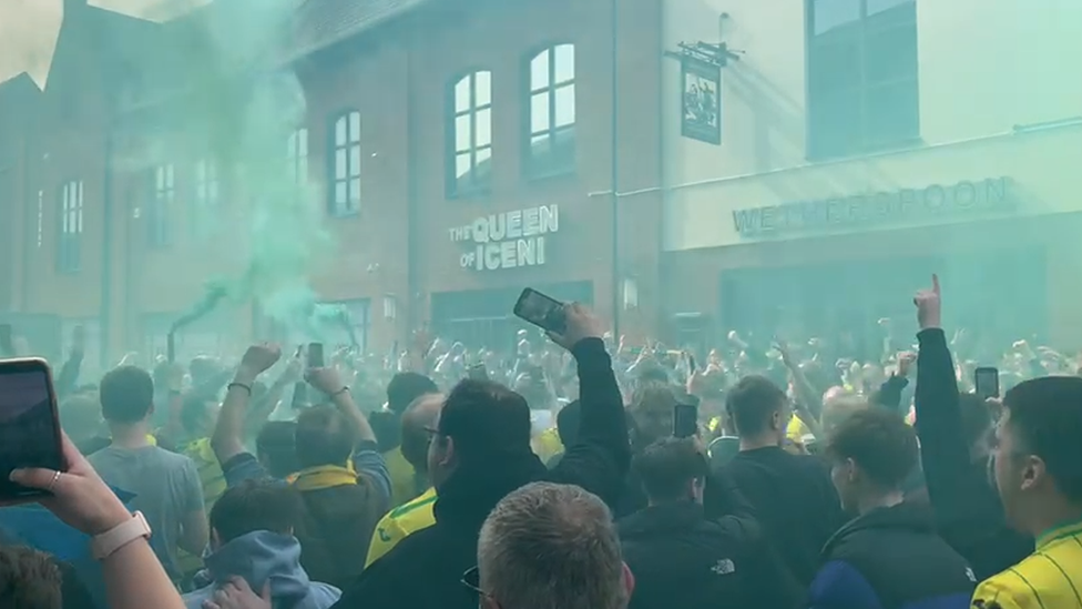 Fans with flares outside The Queen of Iceni pub on Riverside