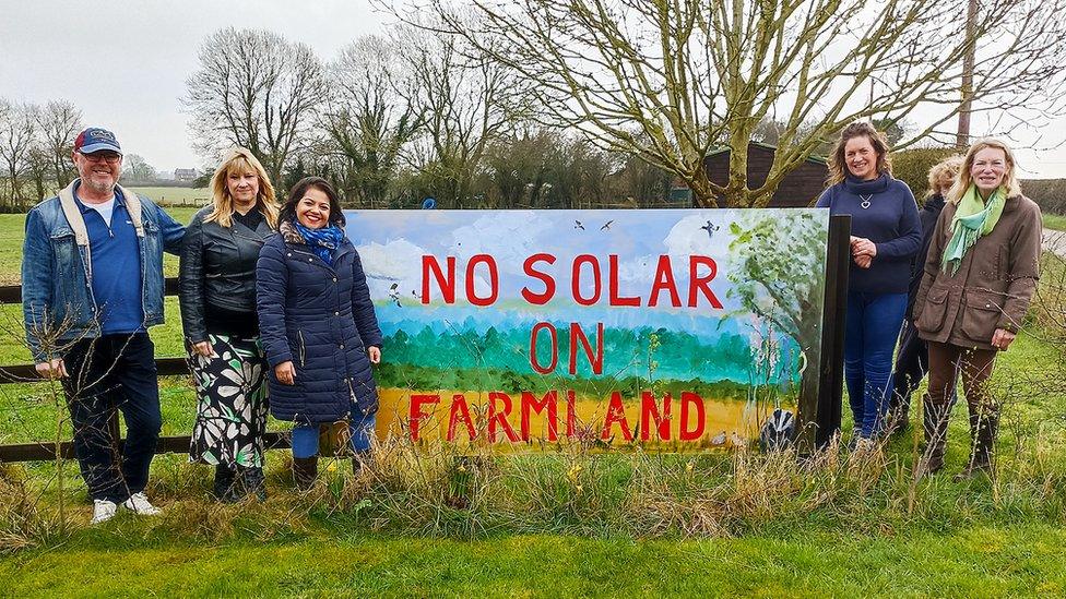 Six people standing by a banner