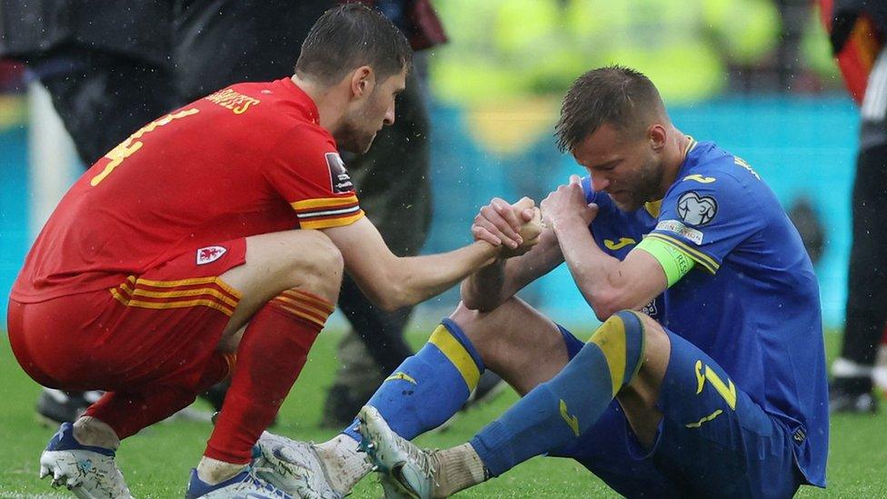 wales-player-comforts-Ukraine-player