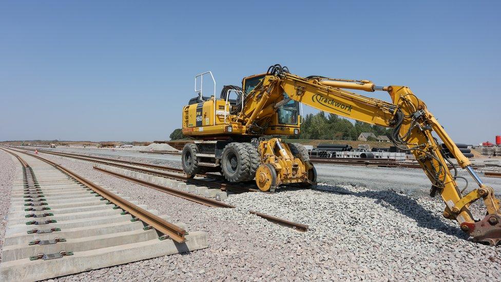 Construction work at the site with a yellow digger in the foreground