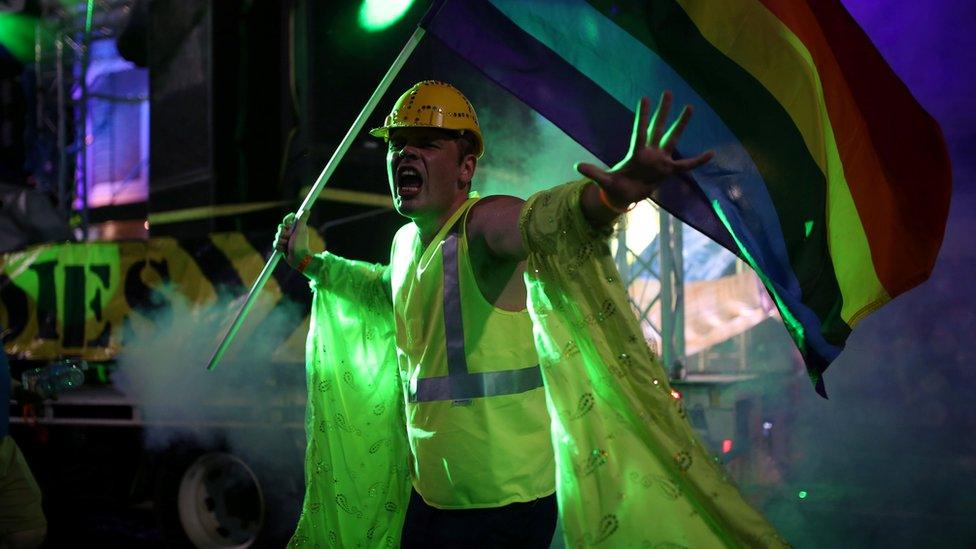 A participant in a construction outfit marches with the rainbow flag during the annual Sydney Gay and Lesbian Mardi Gras parade in Sydney, Australia March 4, 2017.