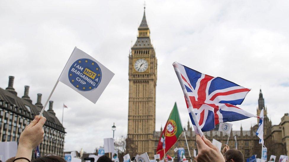 Flags are waved in front of the Elizabeth Tower, better known as 'Big Ben', near the Houses of Parliament during a 'Flag Mob' demonstration in Parliament Square in central London on February 20, 2017, part of a national day of action in support of migrants in the UK